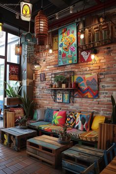 a living room filled with lots of furniture next to a brick wall covered in pictures