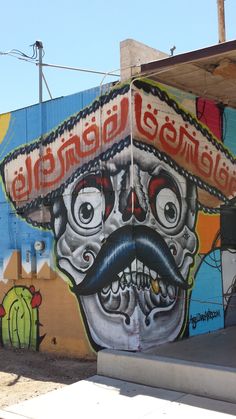 a mural on the side of a building with a skull wearing a sombrero