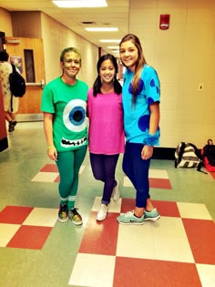 three girls are standing on a checkered floor