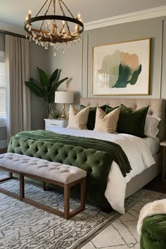 a bedroom with a large bed and green velvet upholstered bench in the middle