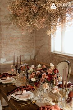 the table is set with candles, plates and napkins for an elegant dinner party