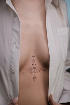 a woman's chest with a tattoo on her left side, and an arrow in the middle