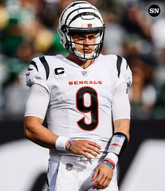 a close up of a football player wearing a helmet and holding his hands on his hips