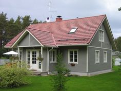 a small gray house with a red roof