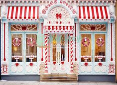 a store front with candy canes and wreaths on the windows