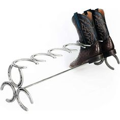 a pair of cowboy boots sitting on top of a shoe rack with horseshoes attached to it