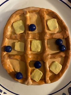 a waffle with blueberries and cheese on it sitting on top of a plate