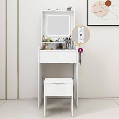 a white vanity with mirror and stool in front of the wall, next to a painting