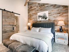 a large bed sitting next to a wooden wall