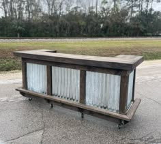 a wooden bench sitting on the side of a road