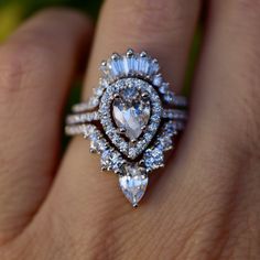 a close up of a person's hand with a ring on their finger and an engagement ring in the middle