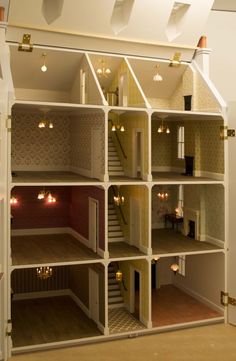 the inside of a doll house with stairs and lights