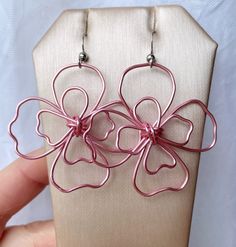 Pink dogwood flower statement earrings. Handworked, pink wire has been wrangled into an abstract, rustic flower motif. These drop earrings are ultra modern and bring an effortless charm into any wardrobe.  One of a kind. Each pair is made to order and slight variations may occur. Earrings are approximately 2" in length, very lightweight, and on surgical steel French earwires. Other colors now available! Makes a beautiful gift for mom, sister, or any trendy, floral loving friend. And you can request gift wrap with a personal gift message to make it all the more perfect! Due to the delicate nature of these earrings they should not be allowed to catch on anything, be pulled on, or worn during any activity where they may come in hard contact with another object. Just an FYI! Each item is intri Flower Statement Earrings, Dogwood Flower, Pink Dogwood, Daisy Jewelry, Rustic Flower, Dogwood Flowers, Rustic Flowers, Flower Motif, Ultra Modern