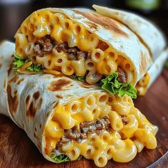 two burritos filled with cheese and meat on a cutting board