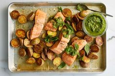 salmon and potatoes with pesto sauce on a tray