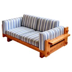 a blue and white striped couch sitting on top of a wooden frame