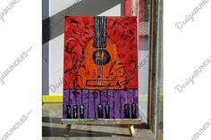 an abstract painting of a guitar in purple, orange and red colors on a wooden easel