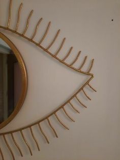 an eye shaped mirror hanging on the wall