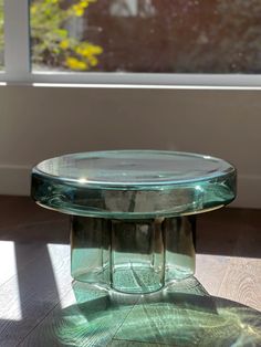 a glass table sitting on top of a hard wood floor next to a large window