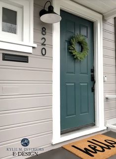 a blue front door with a green wreath on it and the words welcome written in black