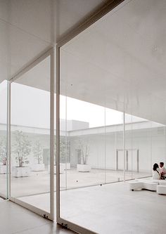 an empty room with glass walls and white floors