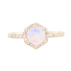 a white opal and diamond ring on a white background