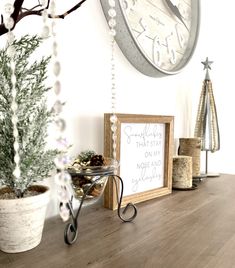 a wooden table topped with a potted plant next to a clock and other decorations