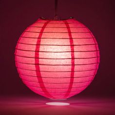 a large pink paper lantern lit up in the dark