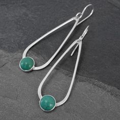 Natural Turquoise teardrop dangle earrings.  8mm turquoise cabochons are set in sterling silver on handmade sterling silver teardrops.  The teardrops swing from solid sterling silver ear wires.  These earrings are 2.25 inches long including the ear wires.  5/8" at the widest point.  8mm turquoise cabochons.For more earrings:https://www.etsy.com/shop/KiraFerrer?ref=hdr_shop_menu&section_id=7937255You may also like:https://www.etsy.com/shop/KiraFerrer?ref=hdr_shop_menu Modern Turquoise Nickel-free Earrings, Modern Turquoise Round Earrings, Modern Teardrop Turquoise Jewelry, Modern Hypoallergenic Turquoise Earrings, Modern Turquoise Hypoallergenic Earrings, Everyday Turquoise Gemstone Earrings, Turquoise Earring, Teardrop Dangle Earrings, Pearl Jewelry Necklace