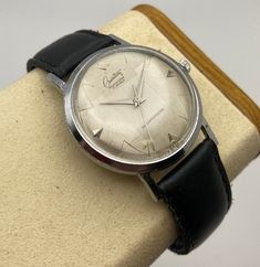 This 1960's Creation "Mastership" watch is very unique, with its geometrically textured silver dial patterned in such a way to give an almost 3-D sphere appearance.  Its indices are a combination of applied arrows and zigzag lines, adding further visual appeal to an already impressive display.  It is a manual winding, shock resisting timepiece, with a 17 jewel Swiss made movement that is winding, setting, and keeping time excellently.  The printed wordmarks on the dial remain in like new appeara Luxury Vintage Manual Winding Watches, Retro Silver Watch Accessories For Formal Occasions, Vintage Engraved Watch For Business, Vintage Engraved Business Watch, Vintage Silver Business Watch, Vintage Silver Watches For Business, Silver Vintage Business Watches, Vintage Silver Watch Accessories For Business, Zigzag Line