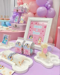 a table topped with lots of desserts and candy bar items on top of a purple table cloth