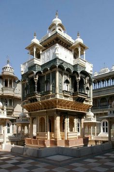 an ornate building in the middle of a checkerboard floored area with several balconies