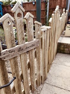 a wooden fence with the name jenny and something written on it is in front of a house