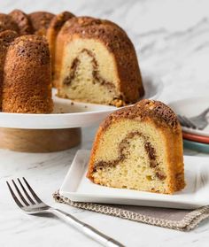 a bundt cake on a white plate with a fork next to the bundt cake