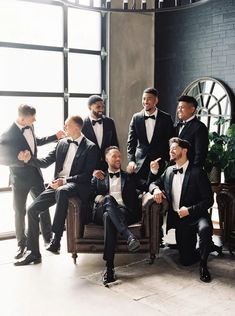 a group of men in tuxedos posing for a photo