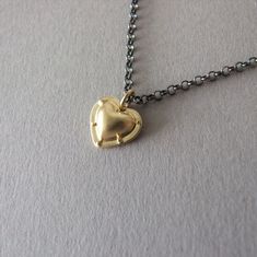 "This is a unique heart necklace, inspired by medieval armor, so if you're looking for a gift for someone who loves the style of the middle ages, this is the gift to give! The pendant is heart-shaped with rivets around a puffed center and has a matte finish. The pendant is made of 14k gold and the chain necklace of blackened silver. You can choose which color 14k gold the pendant will be made of - yellow or white gold I plate the white gold with rhodium, as is common in white gold jewelry. The s Black And Gold Necklace, Gold Heart Pendant, Heart Pendant Gold, Medieval Armor, The Middle Ages, Necklace Heart, Gold Heart Necklace, White Gold Jewelry, Gold Heart