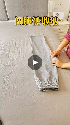 a woman sitting on top of a bed next to a pillow