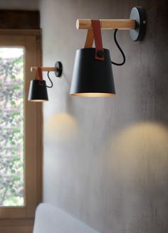 two lamps are hanging on the wall next to a window