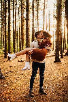 a man carrying a woman in the woods