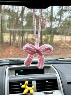 a car dashboard with an air freshener hanging from it's dash board and two yellow rubber figures