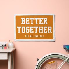 a bicycle leaning against a pink wall next to a sign that says better together the wellingtons