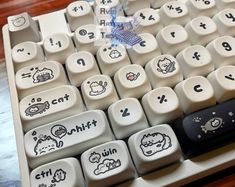 an old computer keyboard with some stickers on it's keys and the words hello kitty written in black ink