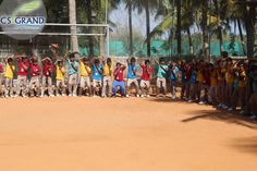 a group of people standing on top of a dirt field