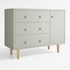 a grey dresser with wooden legs and knobs on it's drawers, against a white background