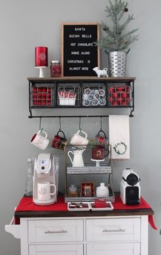 a kitchen with white cabinets and red counter top, christmas decorations on the shelf above it