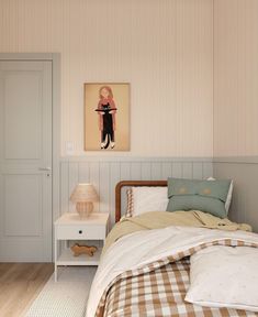 a bed room with a neatly made bed and a painting on the wall