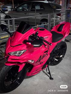 a red motorcycle parked next to a car