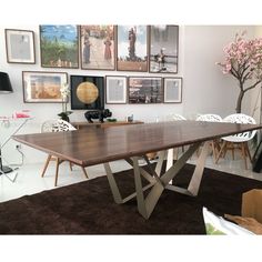 a large wooden table in a room with pictures on the wall