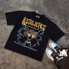 Our journey began with the Resilience Tee - the first step in creating our clothing brand. Crafted from 240 GSM organic cotton, it showcases a high quality digital print on the front and a sleek high-density print on the back. Our Journey, First Step, Clothing Brand, Organic Cotton, Sleek, Digital Prints, The First