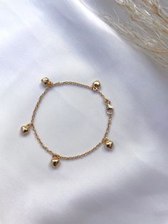 "Solid 14k gold bracelet with hanging puffed hearts. The bracelet length is 6'\" The hearts measure 5.4mm x 4.8mm This bracelet is adorable and sturdy, perfect for babies and toddlers. Bracelet can be lengthened or shortened upon request. All photos are natural and have been taken to the best of our ability. ❤ We guarantee that the item is identical as the actual photo seen. ❤ We Guarantee 100% Pure 14K Gold ❤ Please feel free to message us with any questions you may have ❤ All our Items are als 14k Gold Charm Bracelet With Heart Charm, Dainty Yellow Gold Charm Bracelet With Heart, Gold Dangle Heart Charm Bracelet, Gold Dangle Charm Bracelet With Heart Charm, 14k Gold Yellow Gold Charm Bracelet With Heart Charm, 14k Yellow Gold Charm Bracelet With Heart Charm, Dainty Gold Charm Bracelet With Heart Charm, Puffed Heart, Butterfly Bracelet